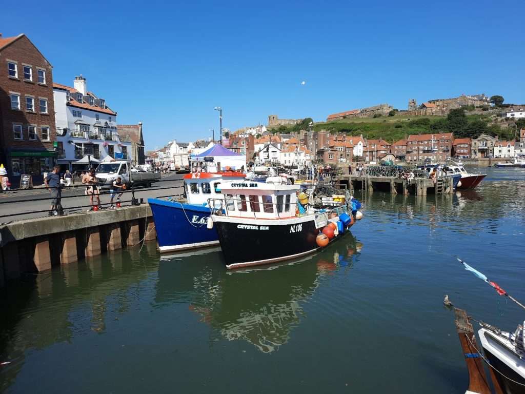 Image of two boats in Whitby Harbour on a lovely sunny day